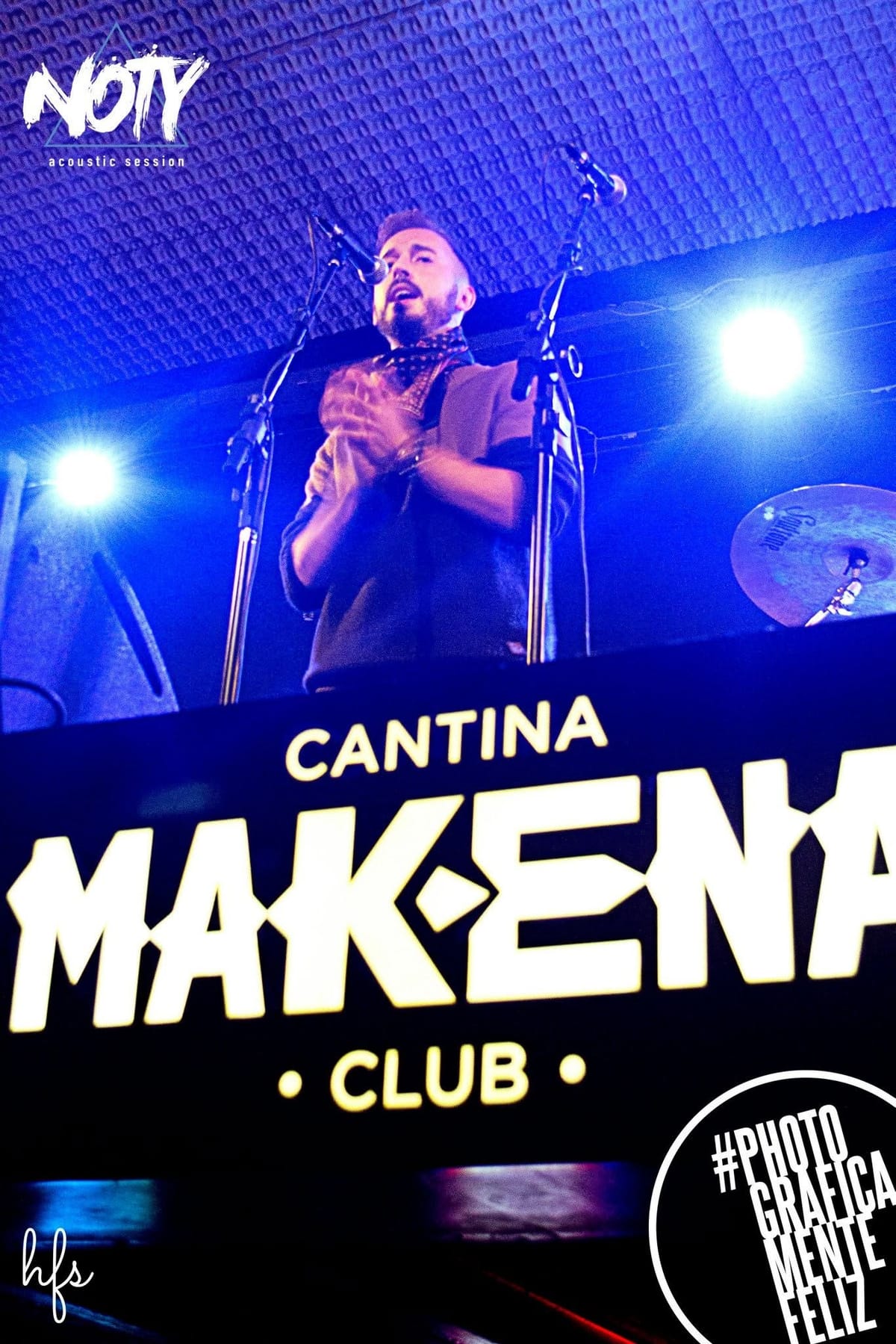 El cantante lleva una mano hacia el rostro en un gesto de intensidad emocional, con desenfoque de movimiento que acentúa la energía del momento.