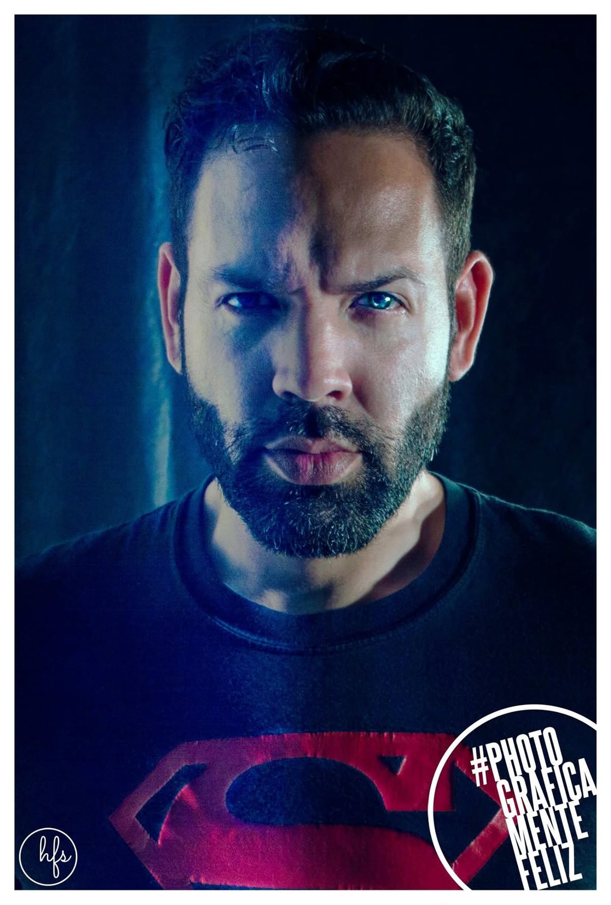 Retrato compuesto digitalmente de un hombre con barba, dividido en dos mitades de iluminación contrastante (azul fría a la izquierda, cálida a la derecha), con los ojos retocados en color…