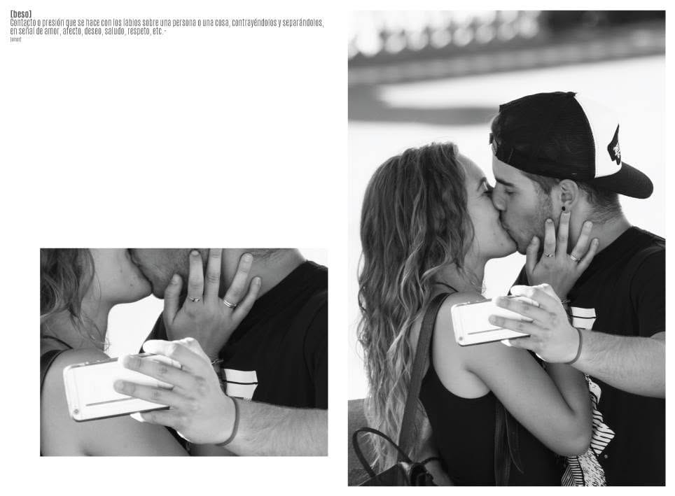 Fotografía en blanco y negro de una pareja joven besándose mientras se fotografían con el celular; ella tiene el pelo ondulado suelto y él lleva gorra hacia atrás.