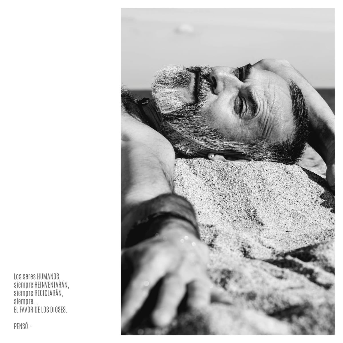 Doble página en blanco y negro con un hombre tendido de espaldas sobre arena, con barba y anteojos, mirando hacia arriba en un gesto contemplativo.