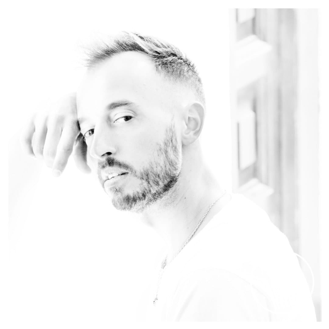 Variante del mismo retrato de alta clave, con el modelo en posición similar pero girado levemente, mirada de reojo hacia cámara y fondo igualmente sobreexpuesto.
