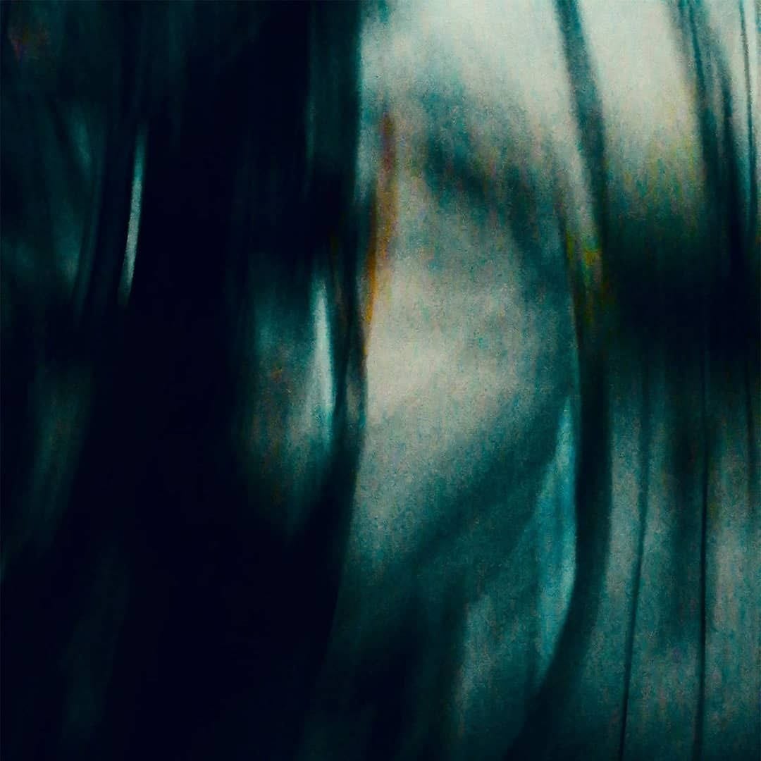 Imagen abstracta con una franja clara y luminosa en la parte superior que se funde hacia trazos verticales oscuros en la mitad inferior izquierda, mientras la derecha permanece casi blanca.
